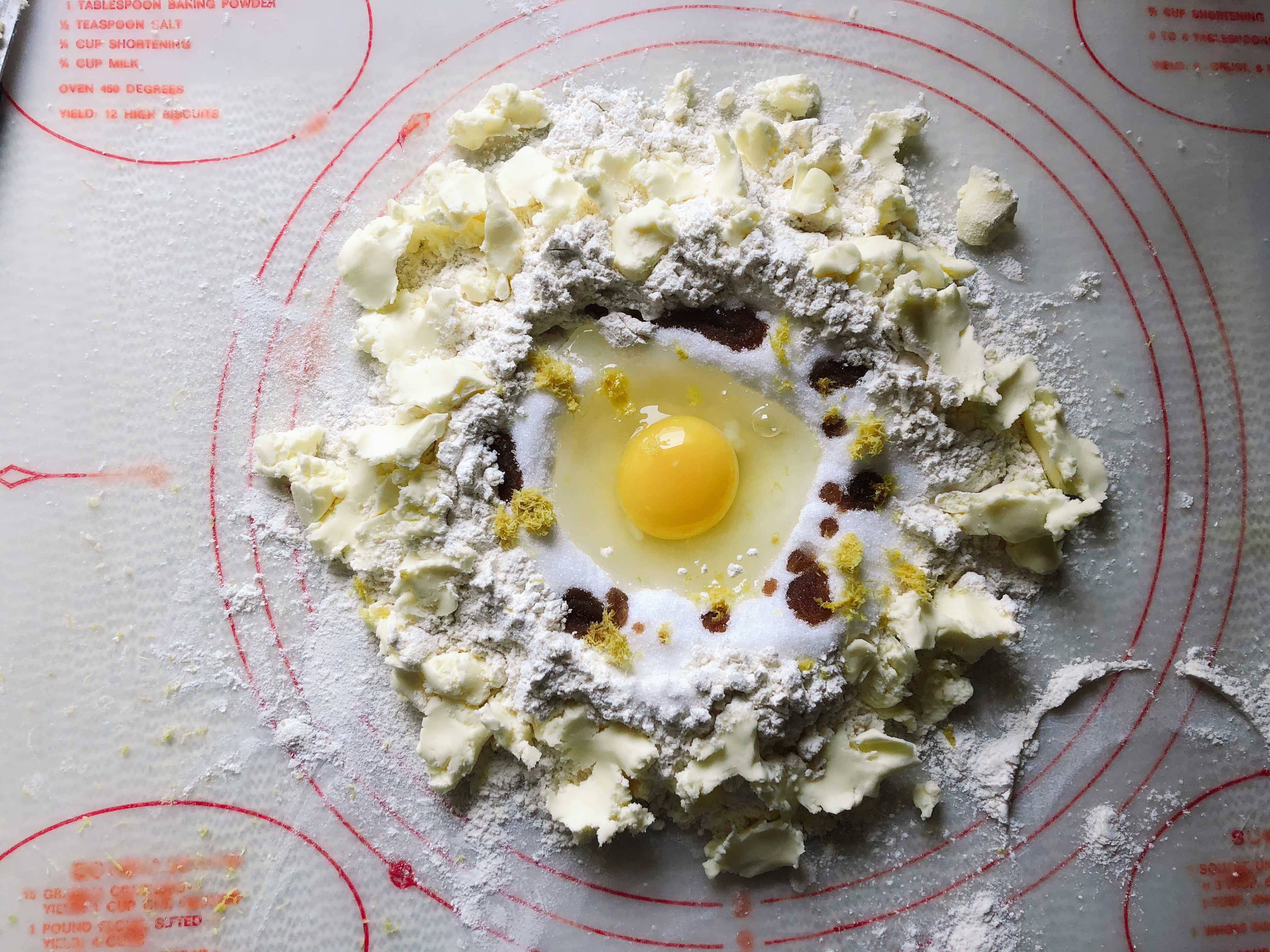 Circles of butter, flour, sugar, eggs and vanilla extract on a baking mat ready to be made into German Plum Spelt Cake (Pflaumenkuchen mit Mürbeteig)