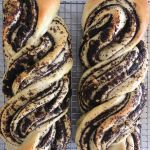 Two poppyseed stollen made from sweet yeast dough cooling on a wire rack