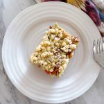 Once square slice of German Rhubarb Streusel Cake (Rhabarber-Streuselkuchen) on a small white plate.