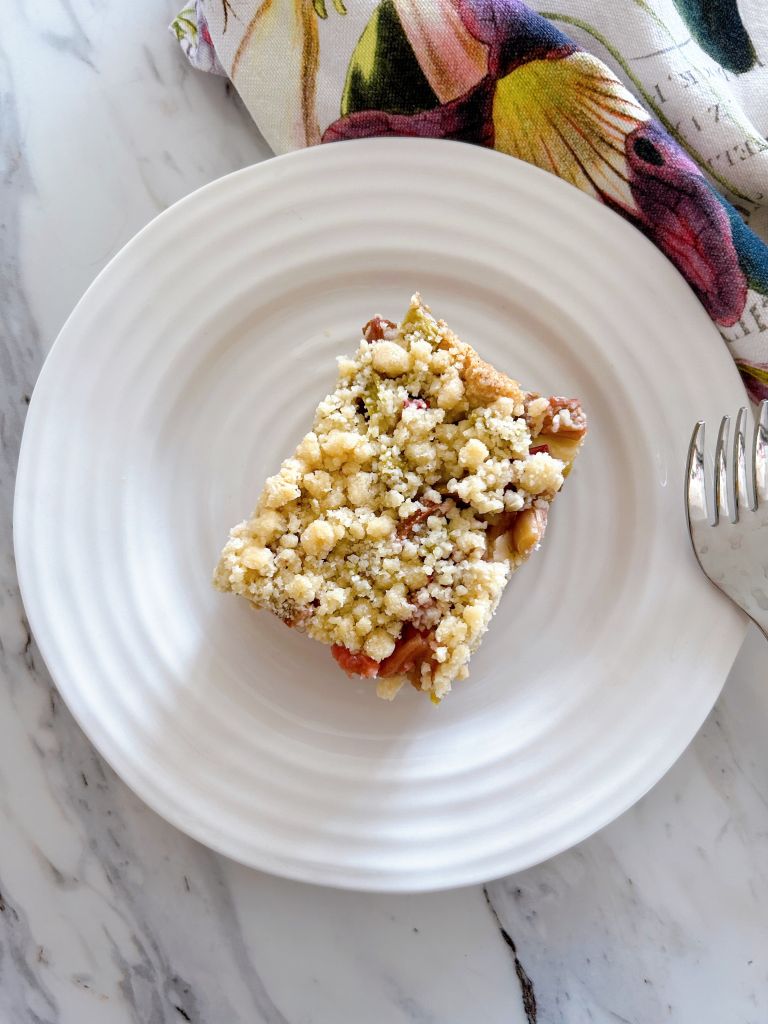 Once square slice of German Rhubarb Streusel Cake (Rhabarber-Streuselkuchen) on a small white plate.